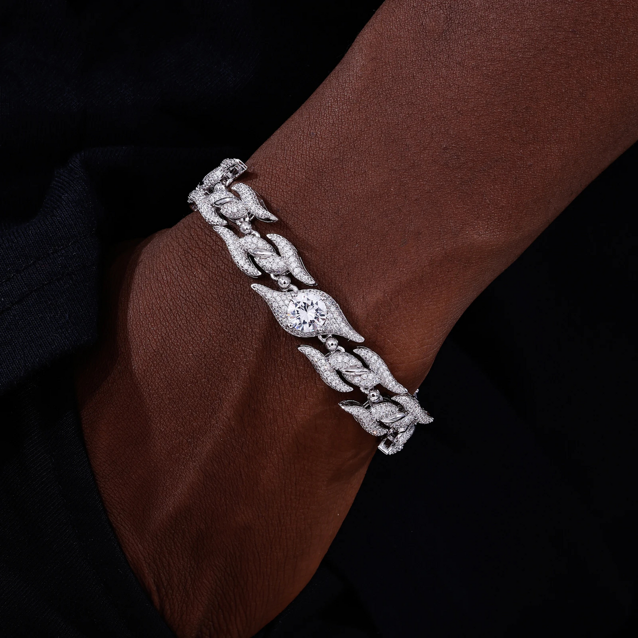 Silver bracelet with a diamond on a wrist against a dark background