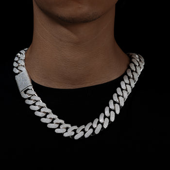 Silver chain necklace on a person against a black background