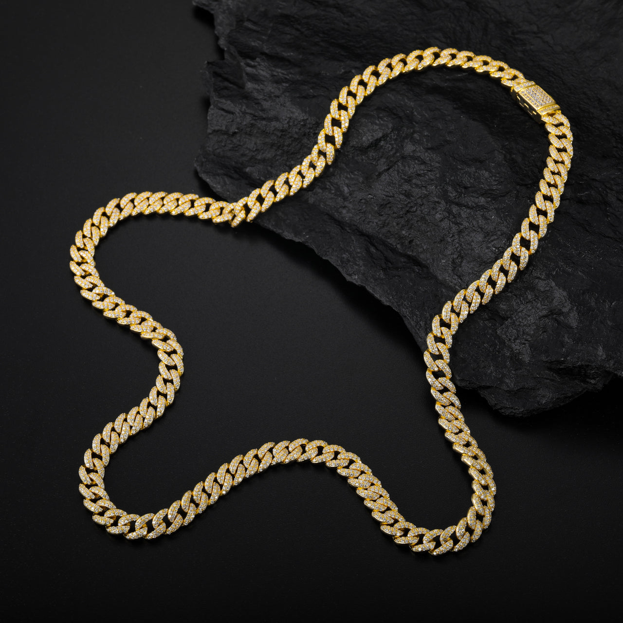 Gold chain necklace on a dark stone surface