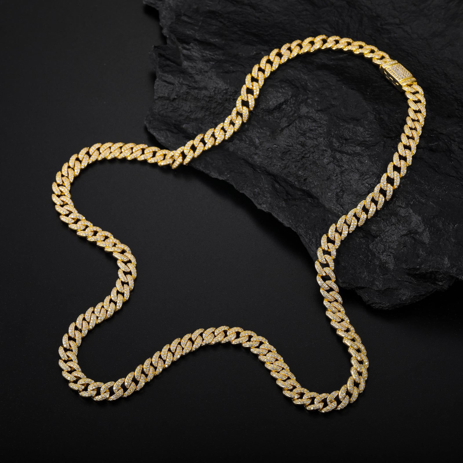 Gold chain necklace on a dark stone surface