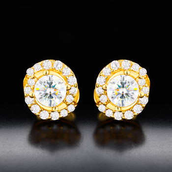 Gold earrings with clear gemstones on a reflective black surface