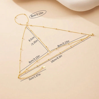 Gold necklace with measurements on a beige background