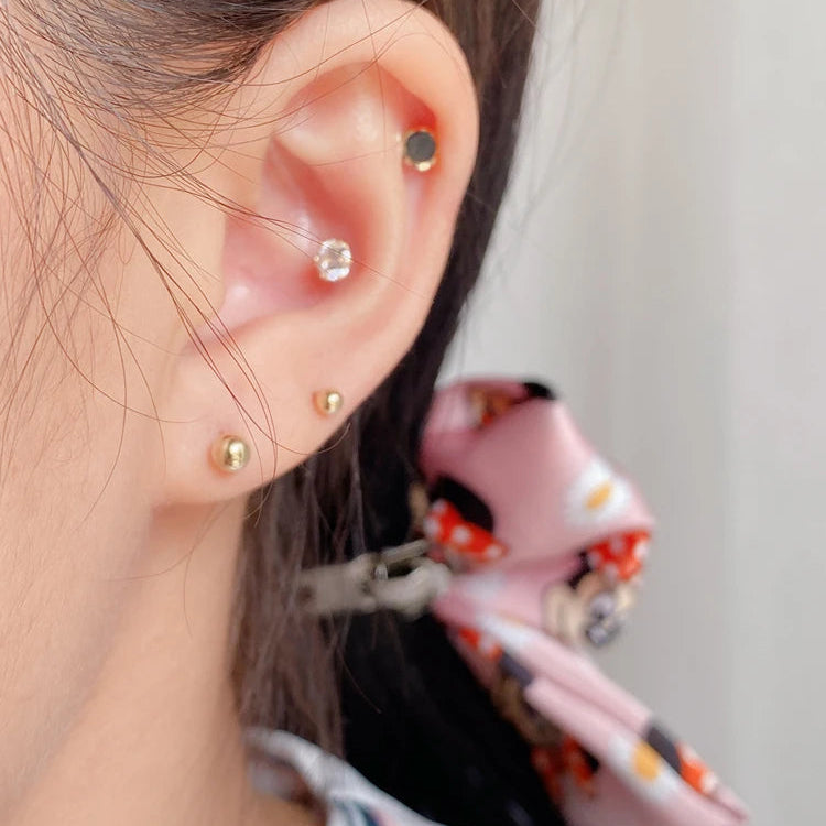 Close-up of an ear with multiple earrings and a blurred background