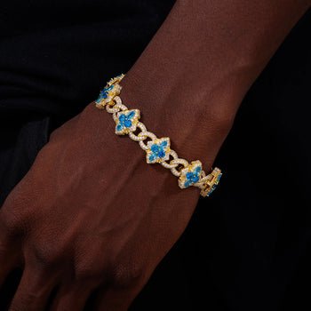 Gold bracelet with blue stones on a wrist against a dark background