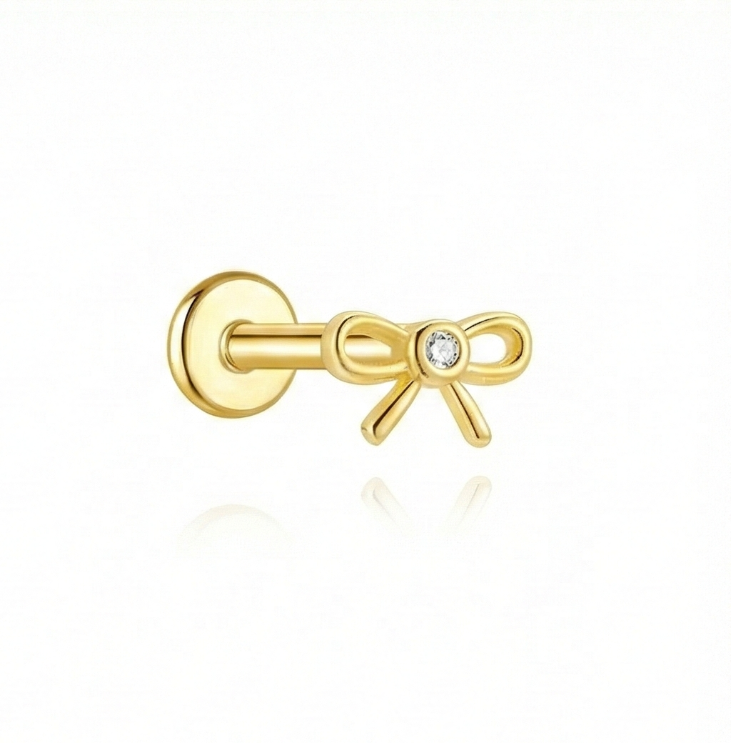 Gold bow-shaped earring with a diamond on a white background