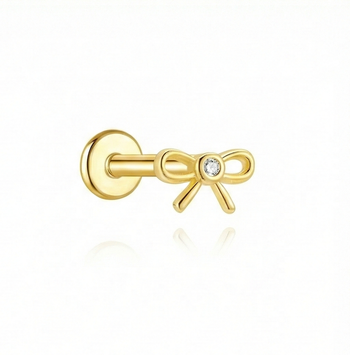 Gold bow-shaped earring with a diamond on a white background