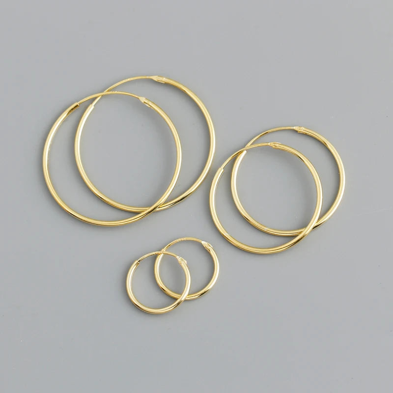 Set of gold hoop earrings on a gray background