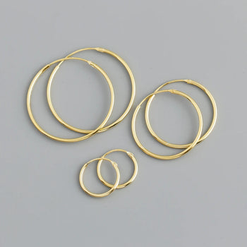 Set of gold hoop earrings on a gray background