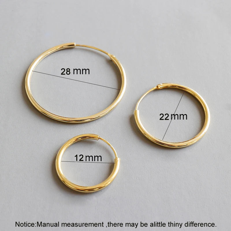 Three gold hoop earrings of different sizes with measurements on a gray background.