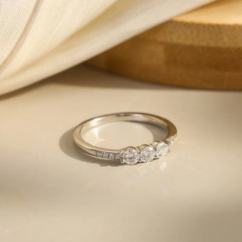 CLASSIC ROUND MOISSANITE THREE-STONE BAND RING IN STERLING SILVER