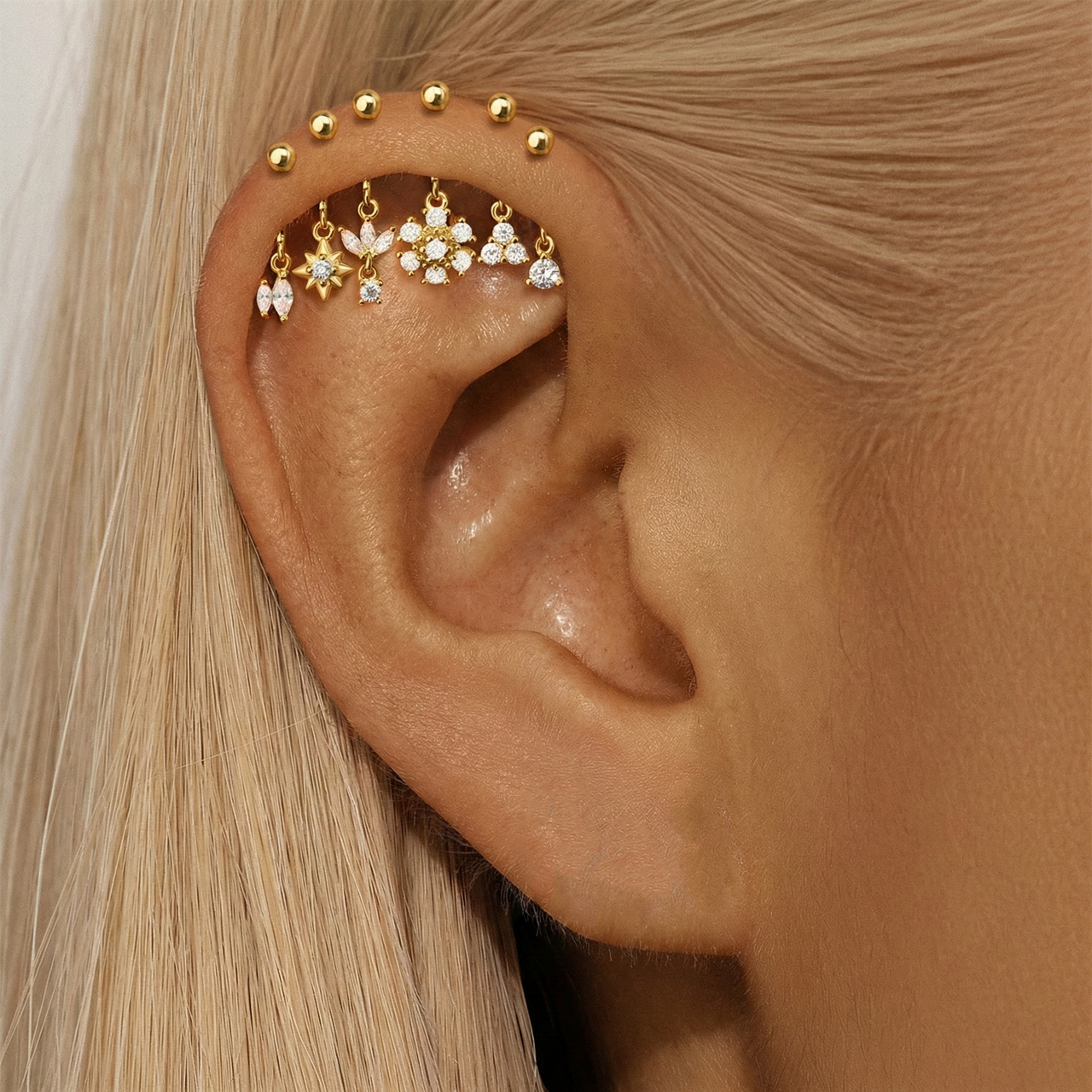 Set of gold earrings with various designs on a white background