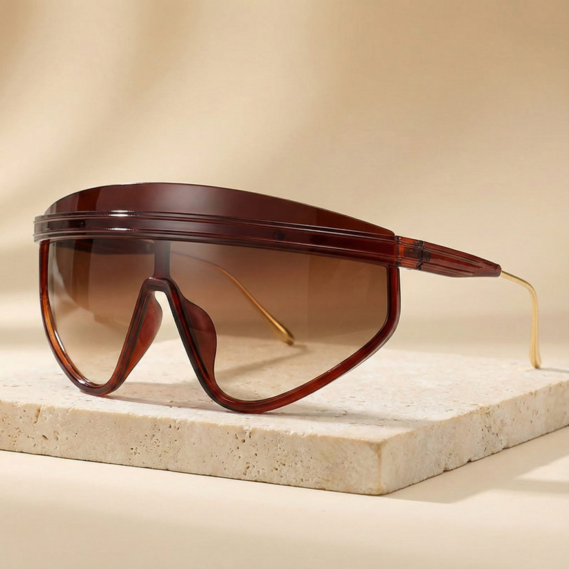 Brown sunglasses with a shield design on a beige surface