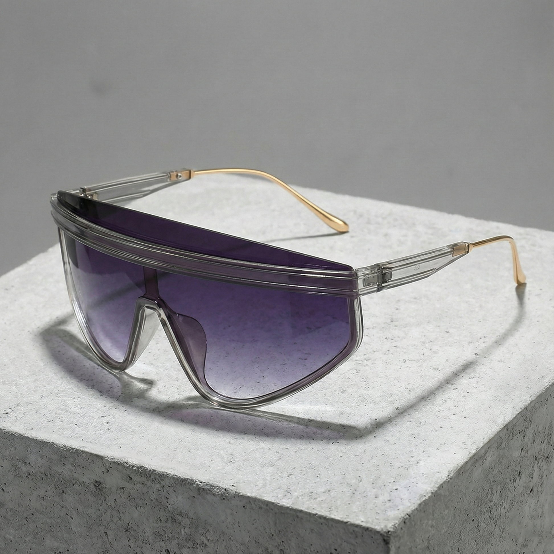 Sunglasses with clear frame and purple lenses on a gray surface