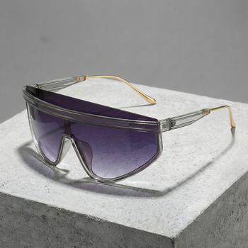 Sunglasses with clear frame and purple lenses on a gray surface