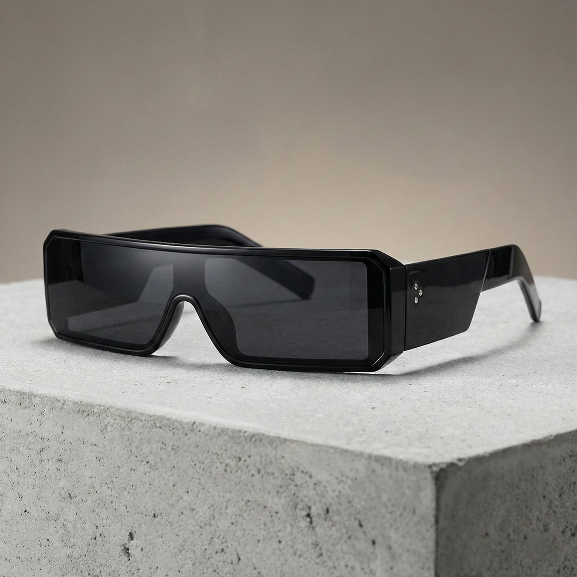 Black sunglasses on a concrete surface with a neutral background