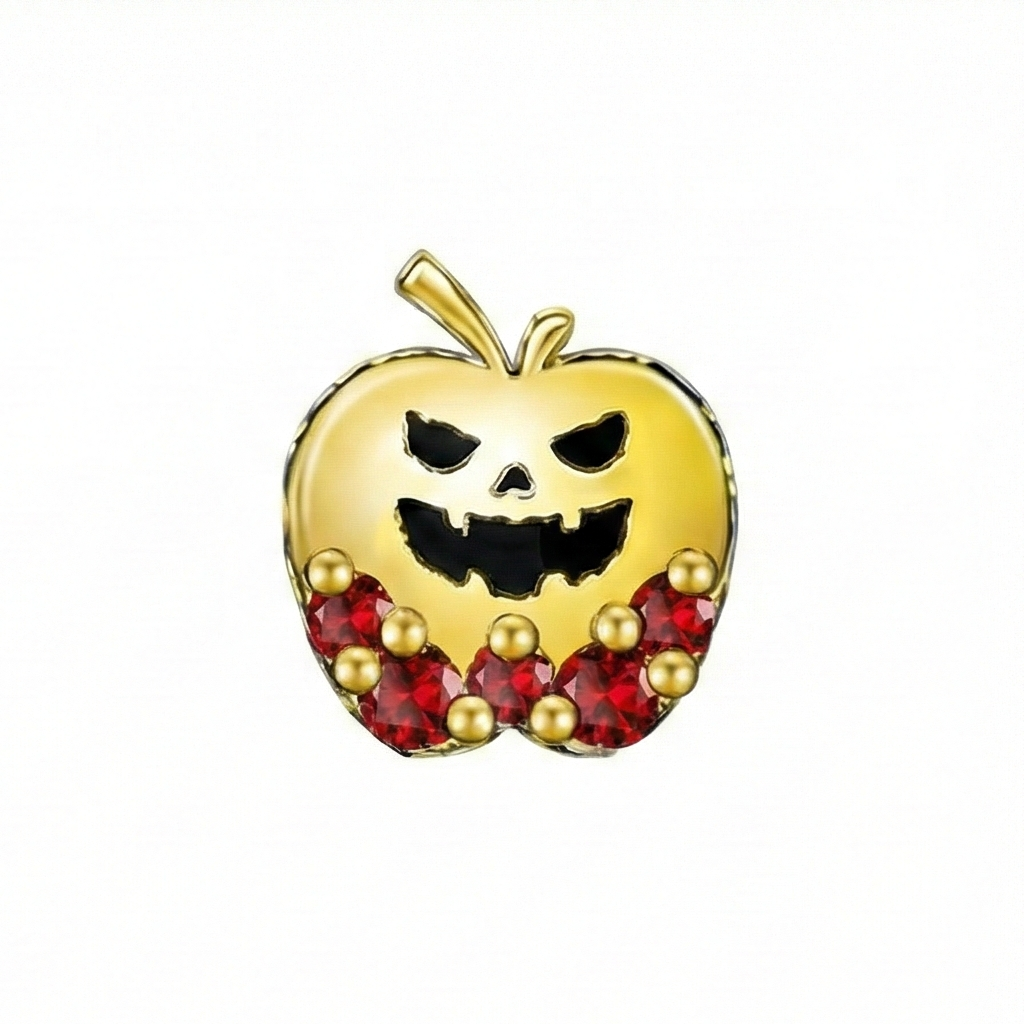 Gold apple charm with red gemstones and a pumpkin face on a white background