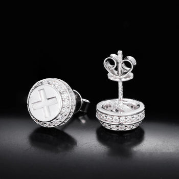 Silver earrings with intricate designs on a black background