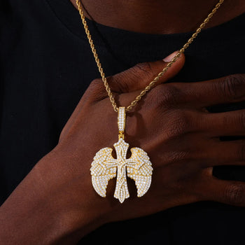 Gold necklace with a detailed pendant held by a person against a dark background