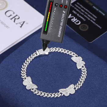Bracelet à maillons cubains en argent sterling orné d'un charm papillon baguette en moissanite. 