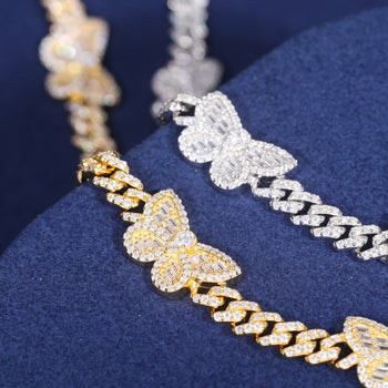 Bracelet à maillons cubains en argent sterling orné d'un charm papillon baguette en moissanite. 