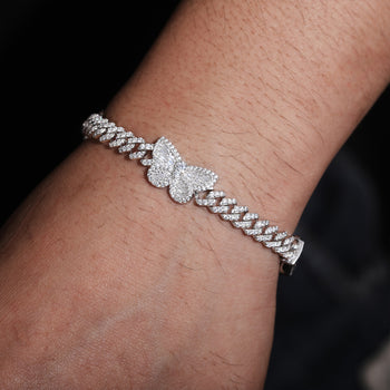 Bracelet à maillons cubains en argent sterling orné d'un charm papillon baguette en moissanite. 