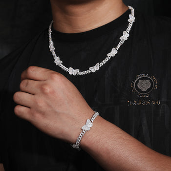 Bracelet à maillons cubains en argent sterling orné d'un charm papillon baguette en moissanite. 