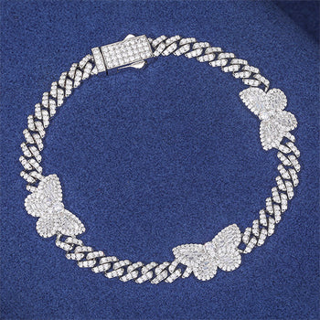 Bracelet à maillons cubains en argent sterling orné d'un charm papillon baguette en moissanite. 
