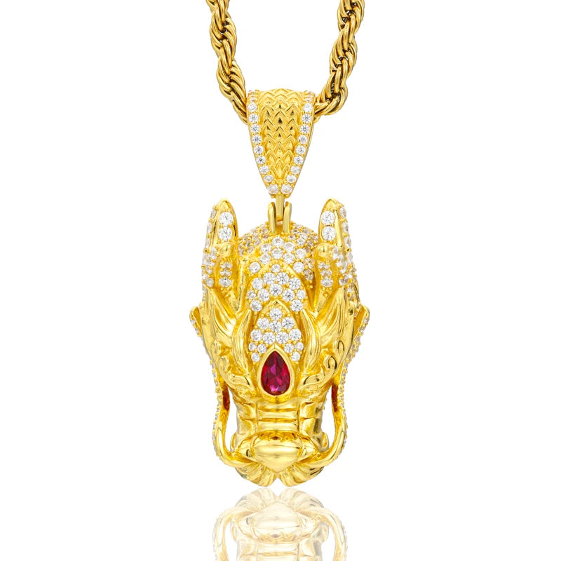 Gold pendant with a red gemstone on a white background