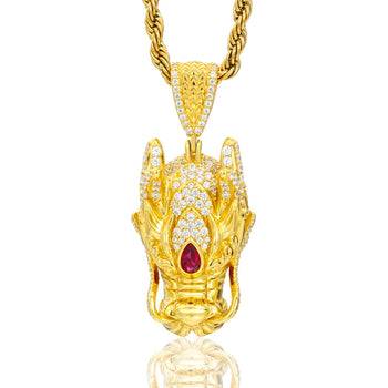 Gold pendant with a red gemstone on a white background