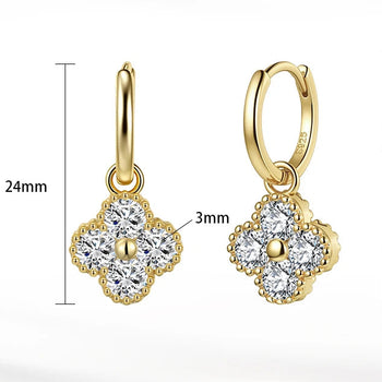 Gold earrings with diamond-like stones on a white background, featuring product details 