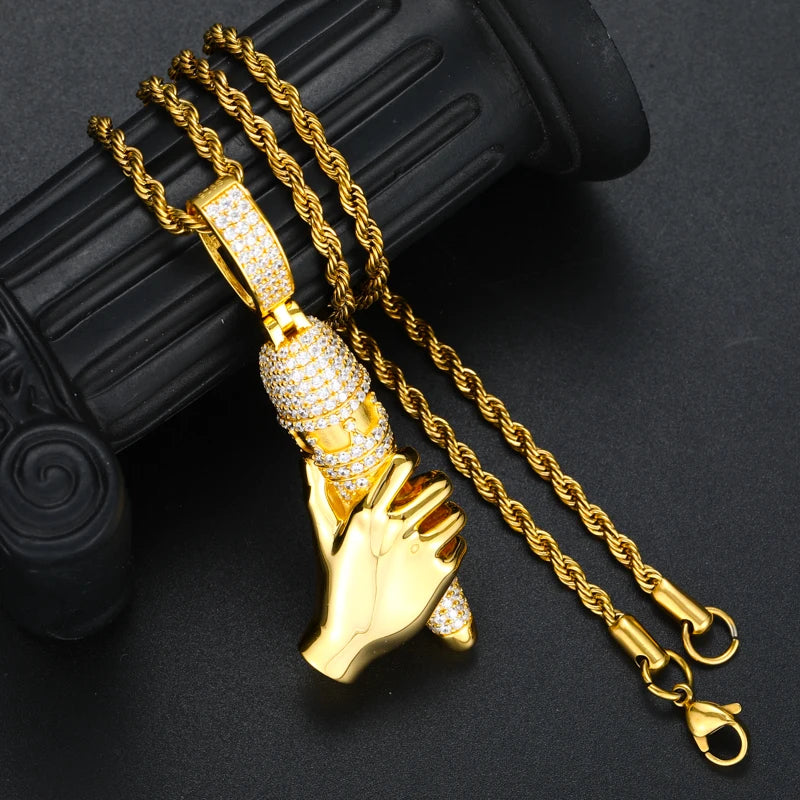Gold hand-shaped pendant with chain on a dark background