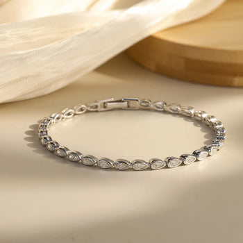 Silver bracelet with marquise-shaped stones on a beige surface