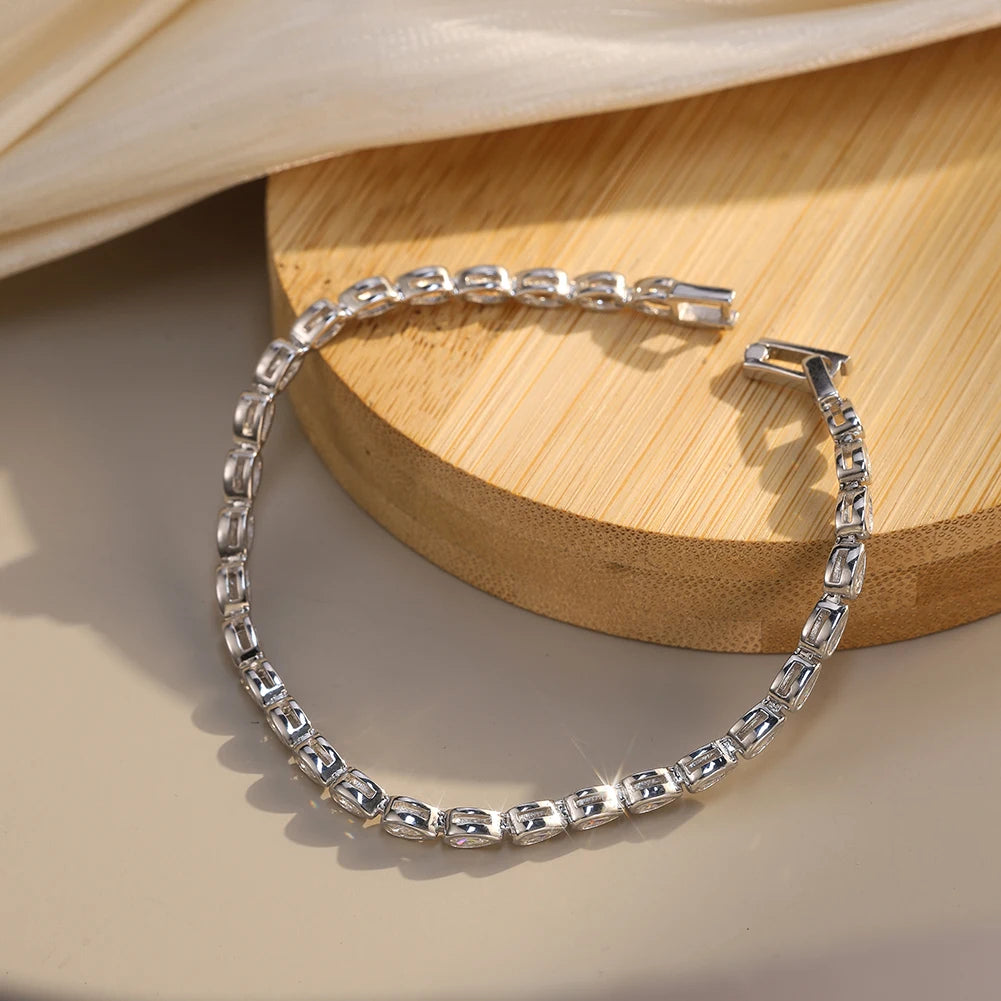 Silver bracelet with marquise-shaped stones on a beige surface