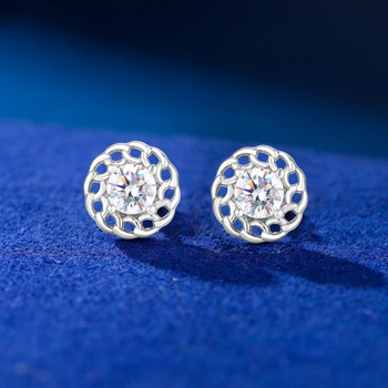 Silver earrings with clear gemstones on a blue textured background