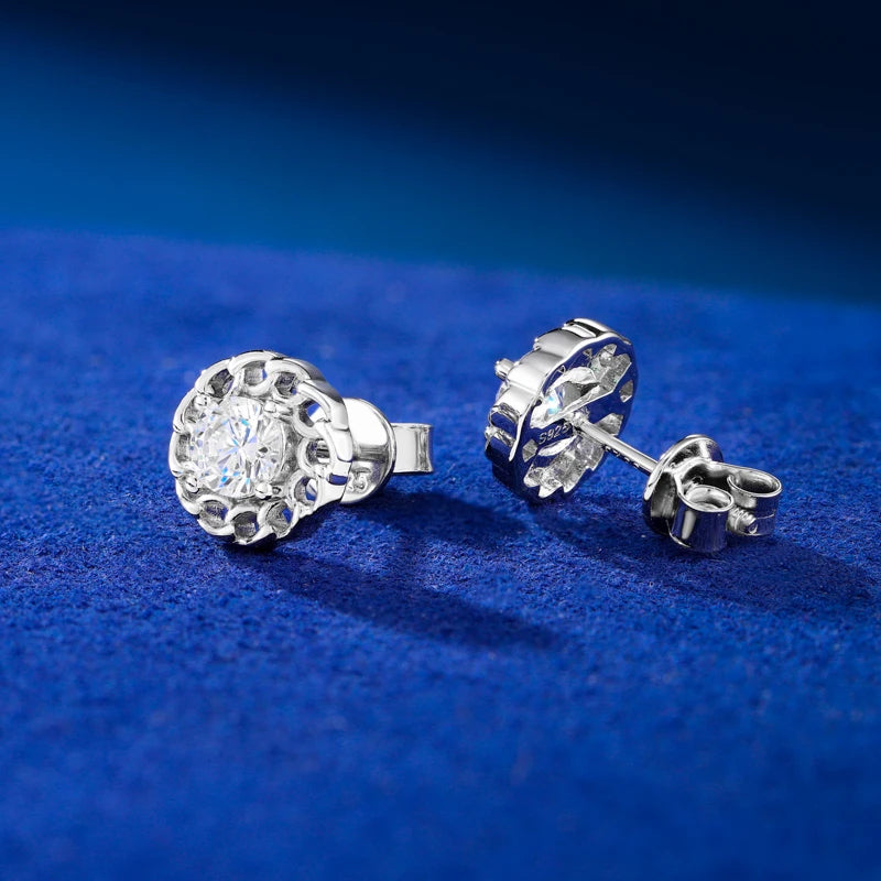 Silver earrings with a central gemstone on a blue textured background