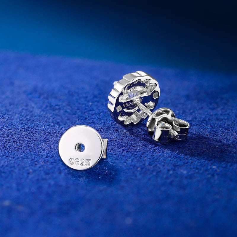 Silver earrings on a blue textured surface