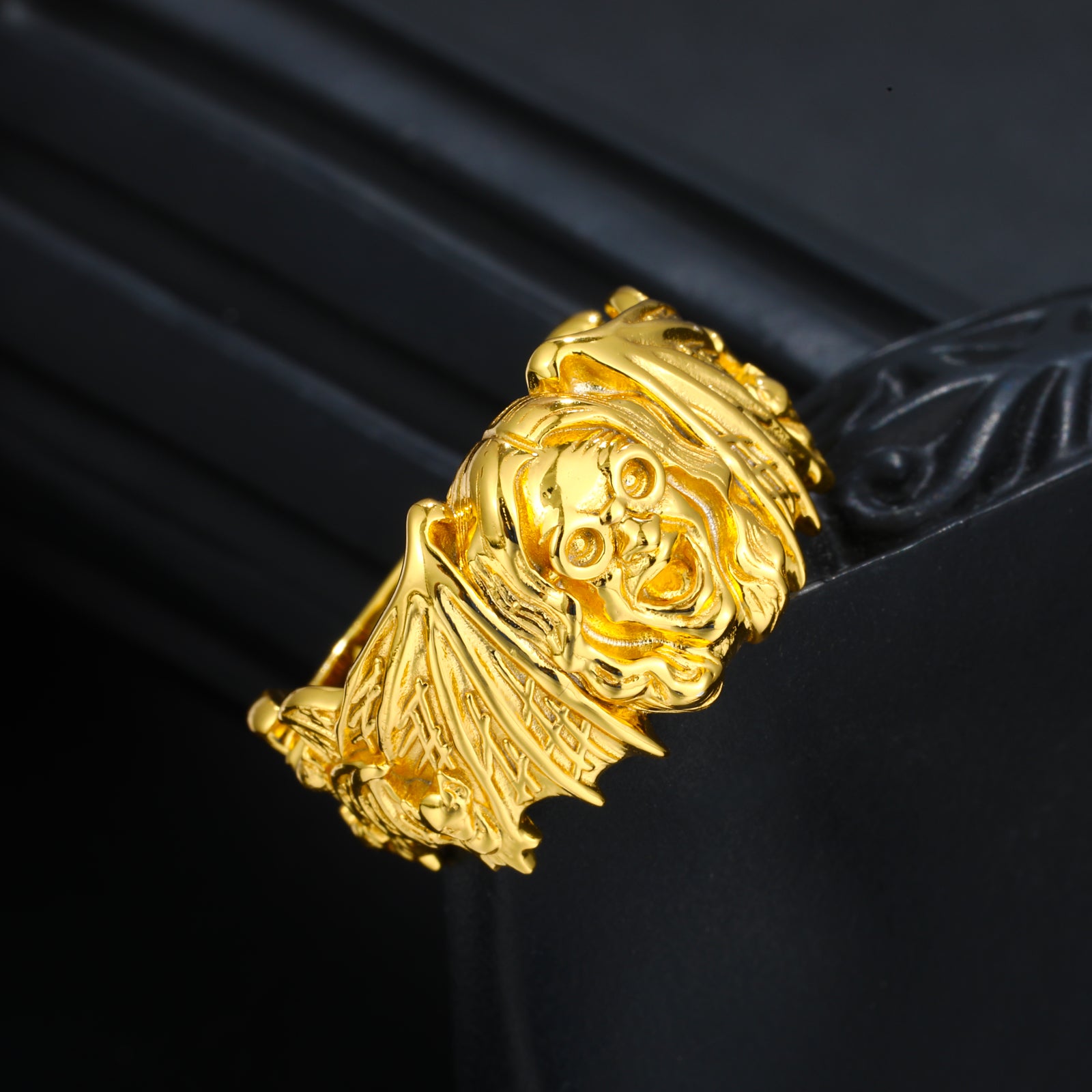Gold bracelet with intricate design on a black background