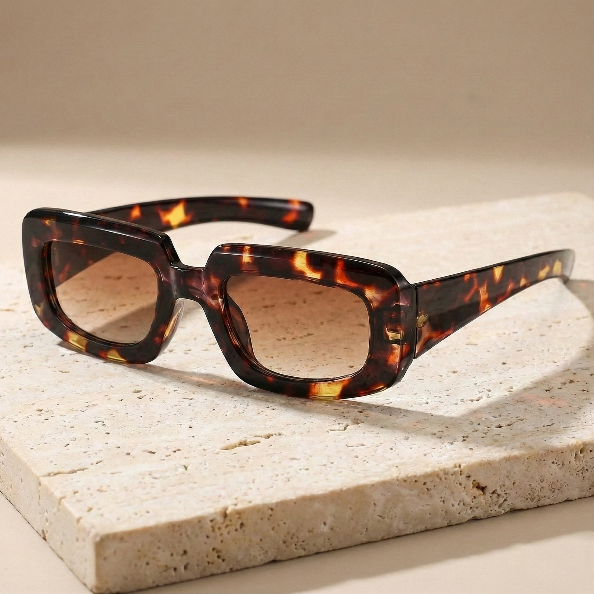 Tortoiseshell sunglasses on a light stone surface
