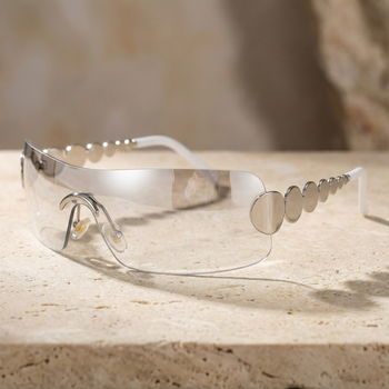 Clear safety goggles with metallic accents on a stone surface