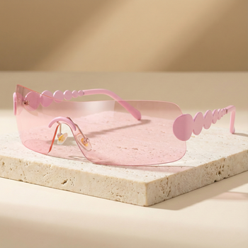 Pink sunglasses with a geometric frame on a beige surface