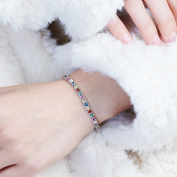 Multicolored beaded bracelet on a wrist with a fluffy white background