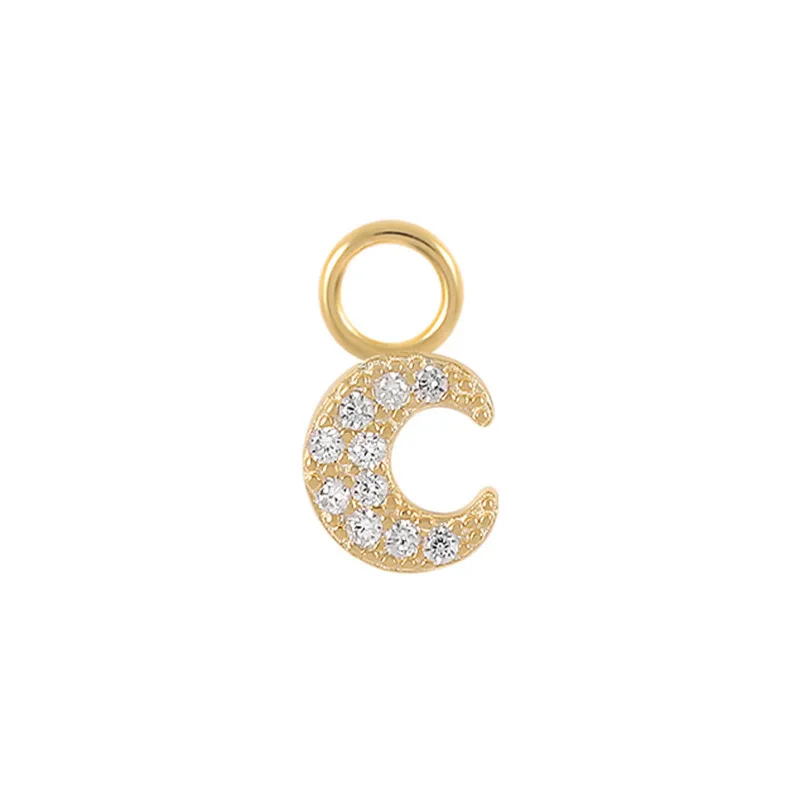 Gold crescent moon charm with embedded stones on a white background