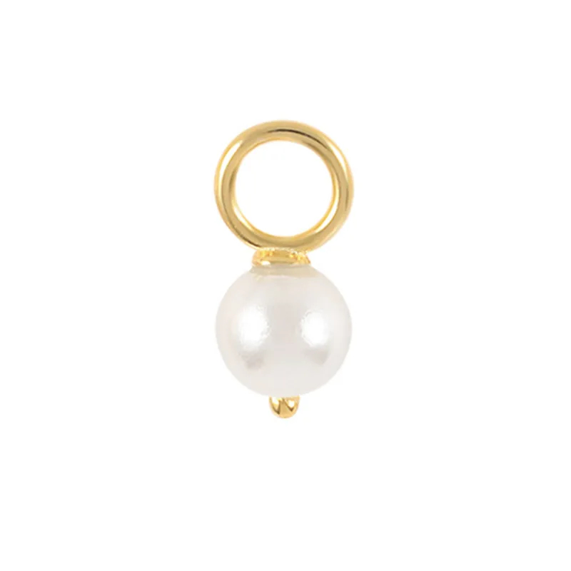 Gold charm with a white pearl on a white background