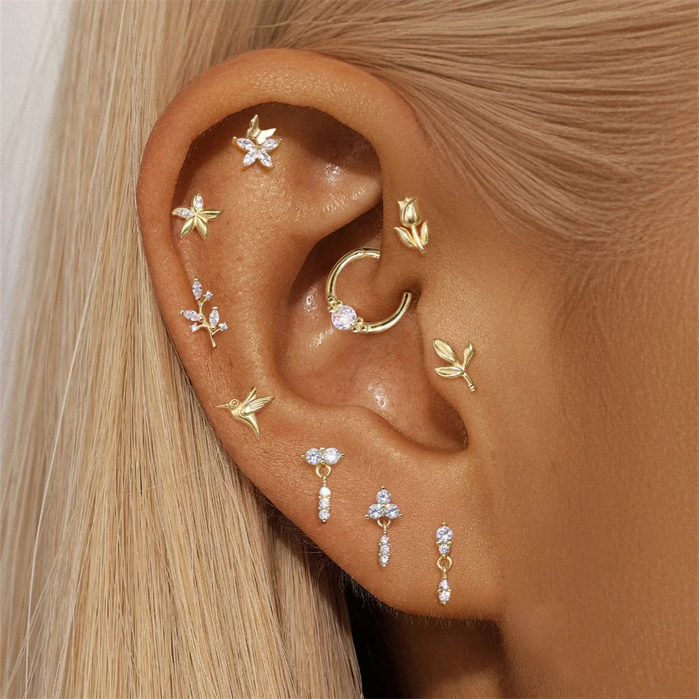 Close-up of an ear with multiple gold and diamond earrings.